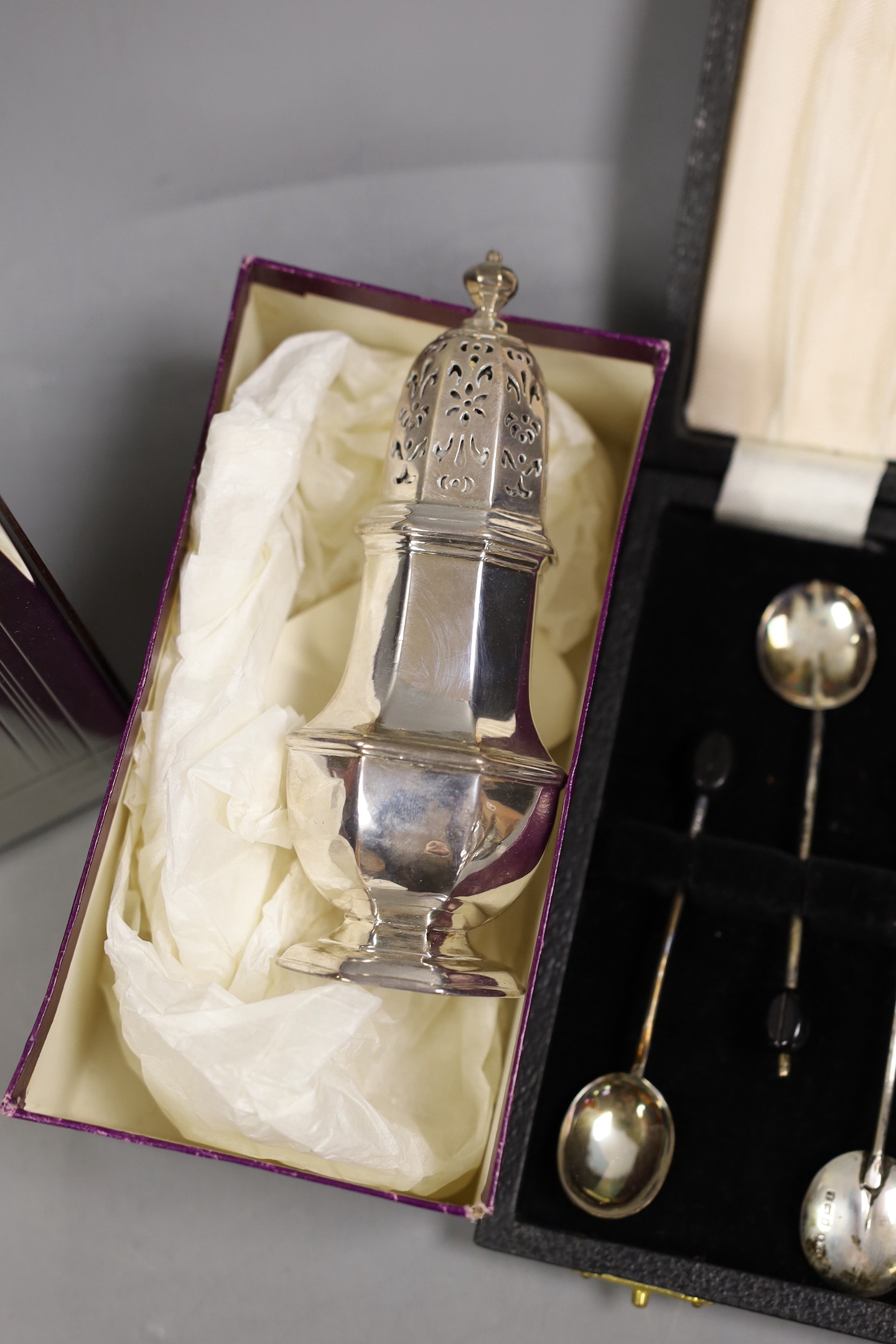 A George I silver octagonal caster, Thomas Bamford, London, 1725, 13.1cm, a cased modern silver commemorative spoon, a cased set of six silver bean end coffee spoons and five plated items.